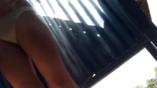 Девушка спокойно переодевается в раздевалке на пляже, не подозревая, что ее снимает скрытая камера